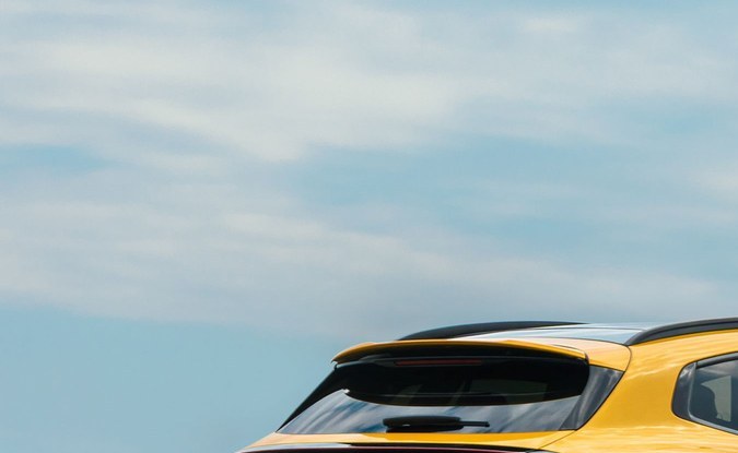 Parte trasera de un SUV eléctrico Mercedes-AMG GT amarillo con calaveras rojas en una pista