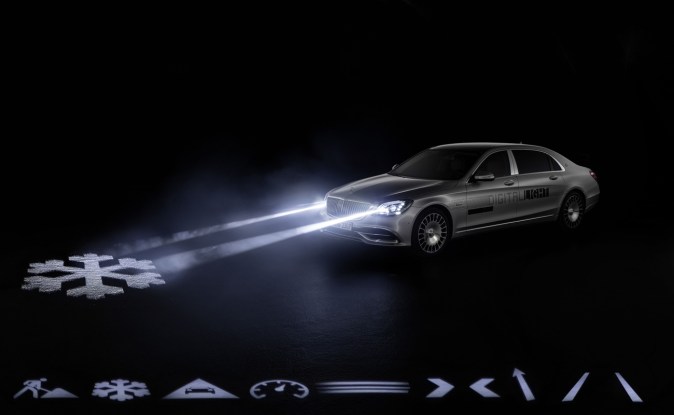 Sedán Mercedes plateado proyecta un copo de nieve en el asfalto con faros DIGITAL LIGHT.