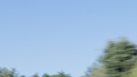 Porsche 911 GT3 Touring azul metálico circulando a alta velocidad por carretera.