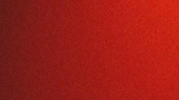 Escudo de Porsche en relieve sobre una superficie oscura iluminada con luz roja, imagen de adelanto del Mission S.
