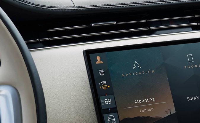 Pantalla táctil central del tablero de un Range Rover, con tapicería clara alrededor.