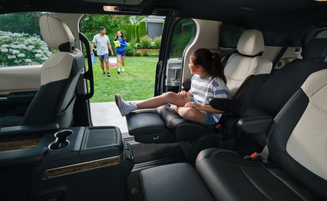Interior de la Sienna con asientos individuales en la segunda fila y una niña sentada junto a la puerta abierta.
