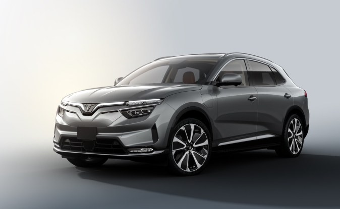 SUV eléctrica VinFast VF8 gris vista de tres cuartos delantero sobre un fondo de estudio blanco.