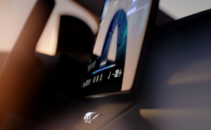 Primer plano de la pantalla táctil vertical del Volvo EX60 con mapa y el asistente Hey Google